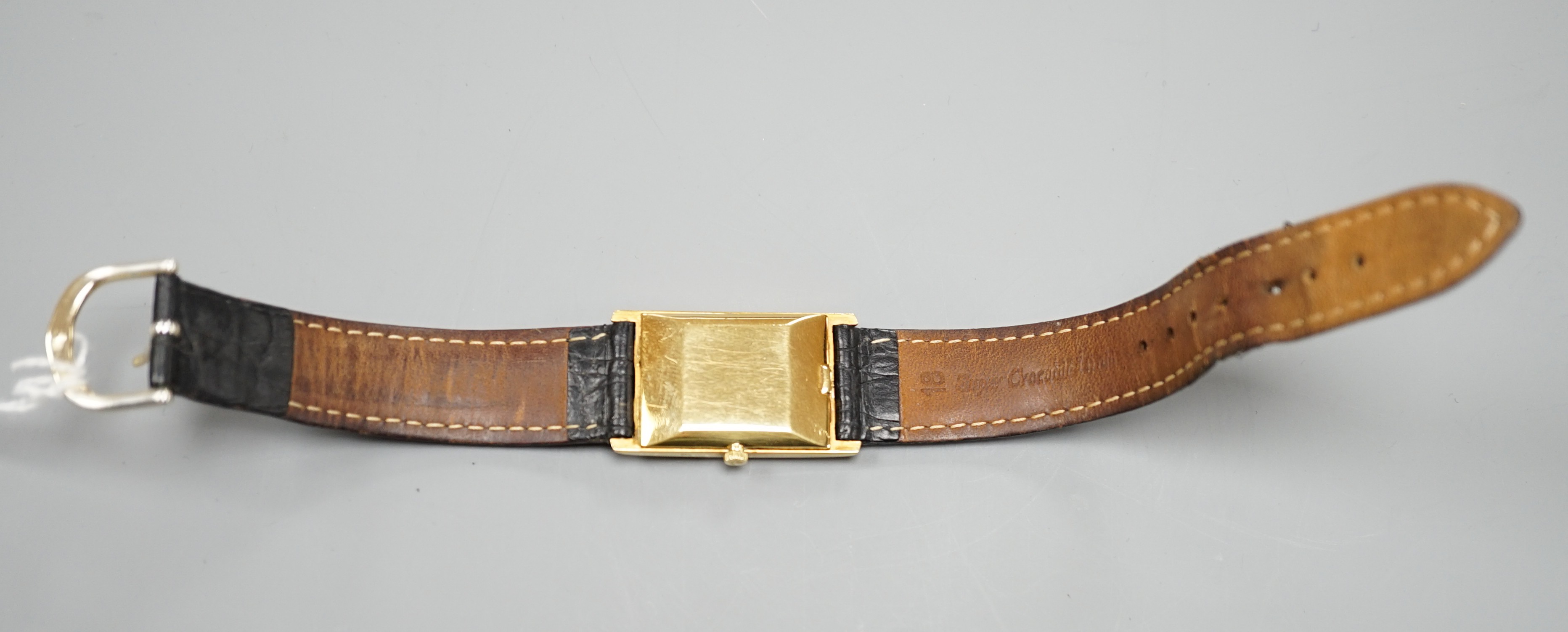 A gentleman's 750 yellow metal Ebel rectangular dial manual wind wrist watch, on associated leather strap, case diameter 22mm, gross weight 24.3 grams.